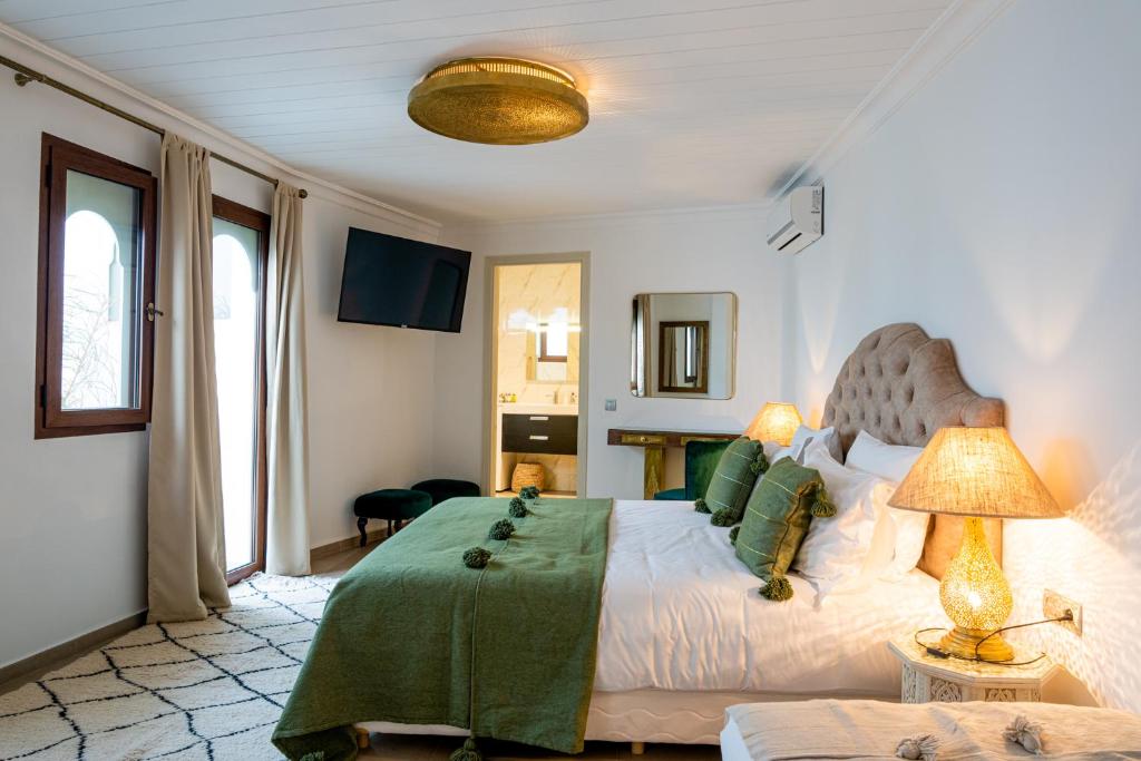 une chambre avec un lit avec une couverture verte dessus dans l'établissement Riad Dar Blanche & Spa, à Marrakech