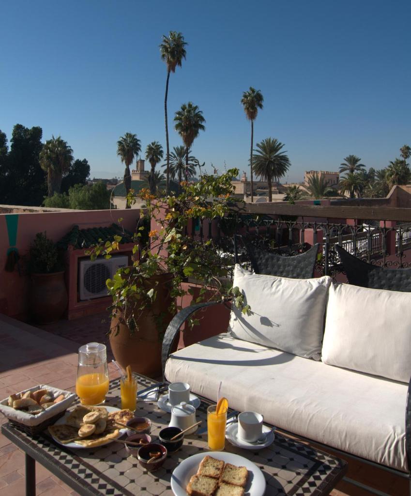 - une table avec un canapé et un plateau de nourriture dans l'établissement Riad Imilchil, à Marrakech