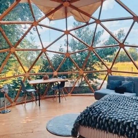 une chambre avec un lit et une table dans une tente dans l'établissement Le Dôme Aux Oiseaux, à Bérig-Vintrange