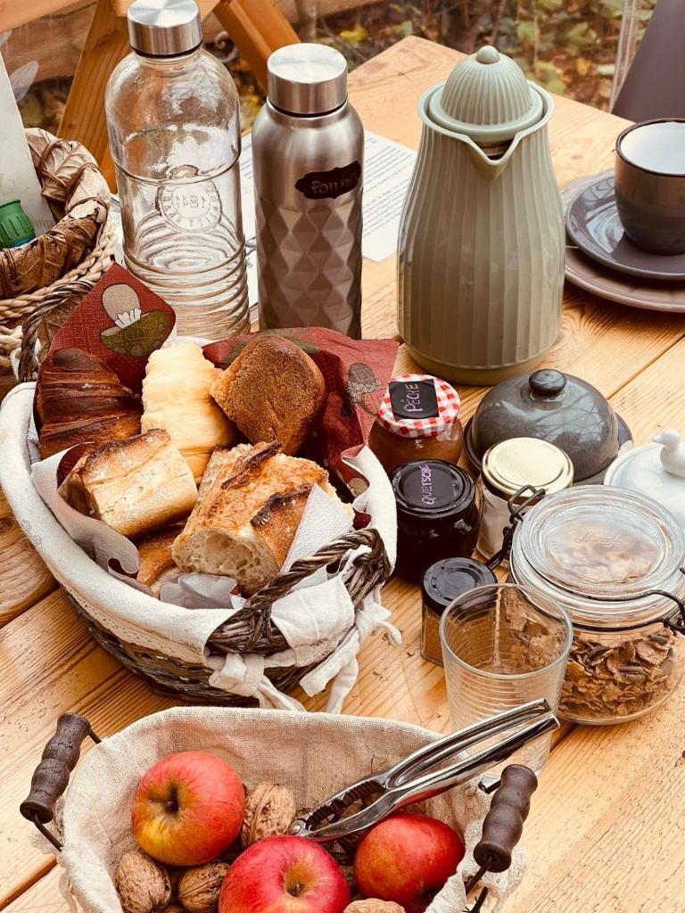 une table contenant des pommes et d'autres denrées alimentaires dans l'établissement Le Dôme Aux Oiseaux, à Bérig-Vintrange