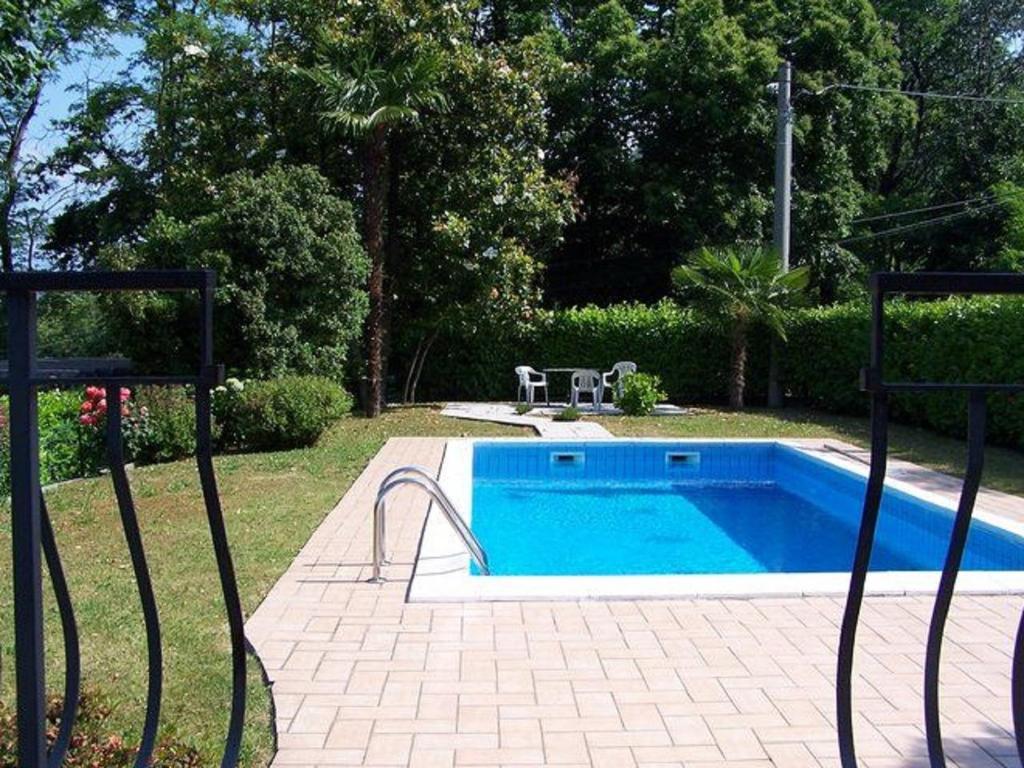 - une piscine dans une cour à côté d'un jardin dans l'établissement Britta, à Brezzo