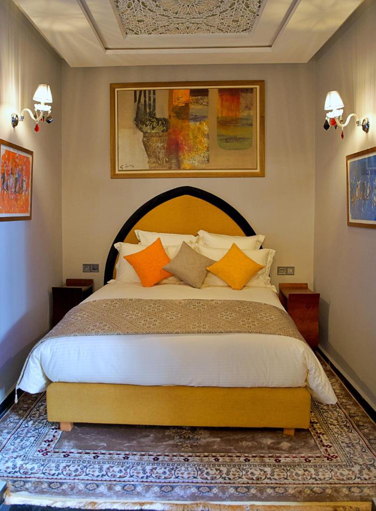 une chambre avec un grand lit avec des oreillers orange dans l'établissement Dar Chrifa, à Rabat