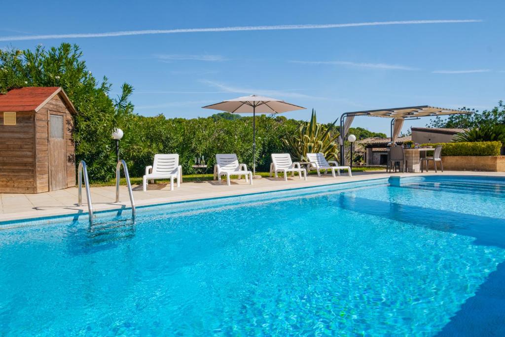 une piscine avec des chaises et un parasol dans l'établissement Villa Mariant con Piscina Privata, à Ruffano