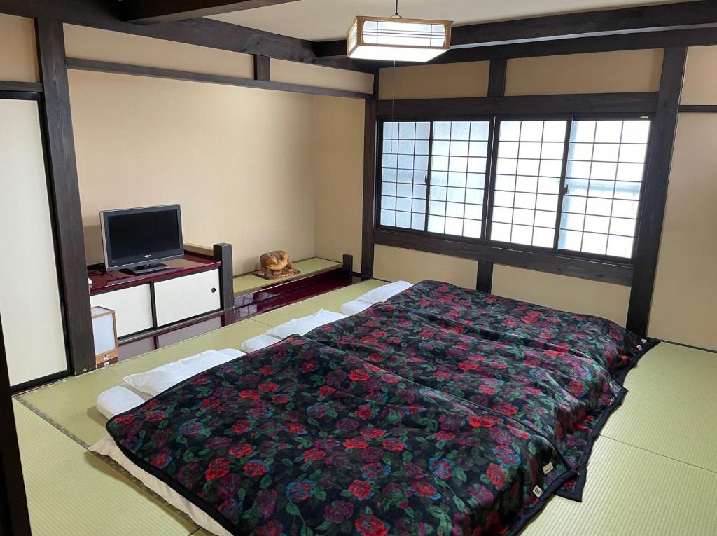 une chambre avec un grand lit et une télévision dans l'établissement Ryokan Murayama, à Takayama 37 autres photos