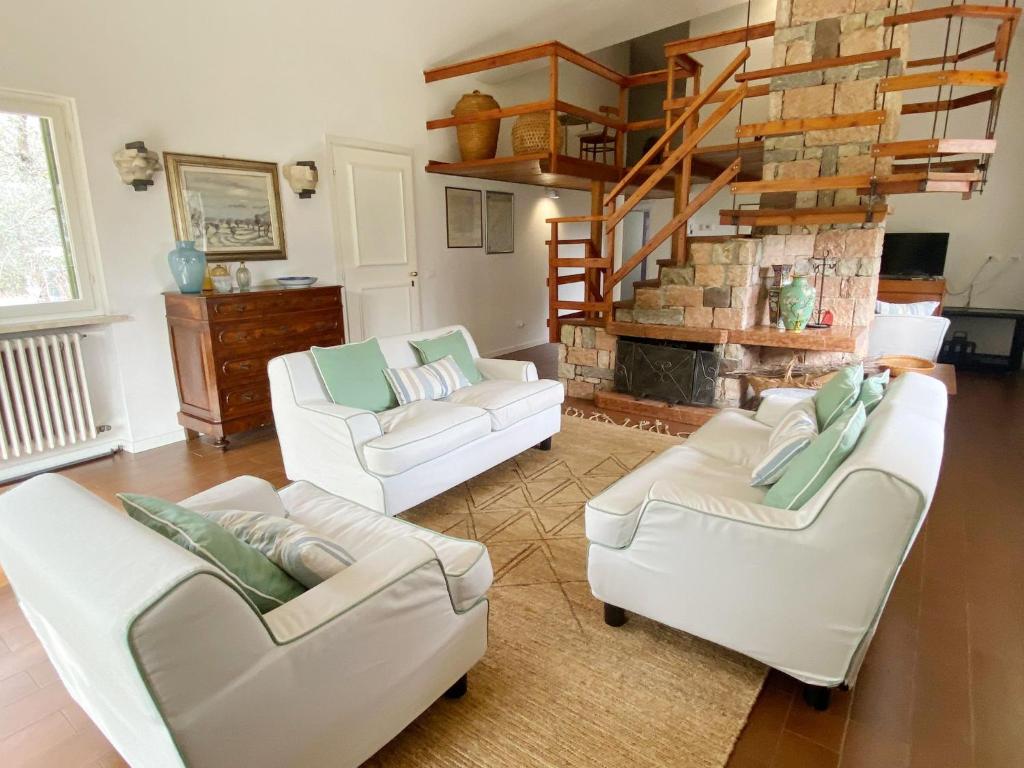 un salon avec deux canapés blancs et une cheminée dans l'établissement Villa Sweet Flower - with Private Pool and Garden, à Manerba del Garda