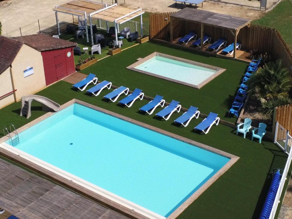 - une vue sur la piscine avec des chaises et une pelouse dans l'établissement Mobil-Home terrasse Semi-Couverte, à Limeuil