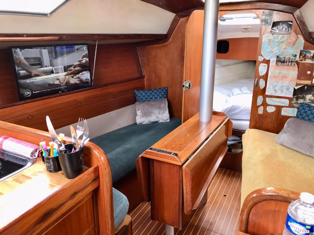 Cette petite chambre comprend un bureau et un lit dans un bateau. dans l'établissement Voilier Loc Han, à Deauville