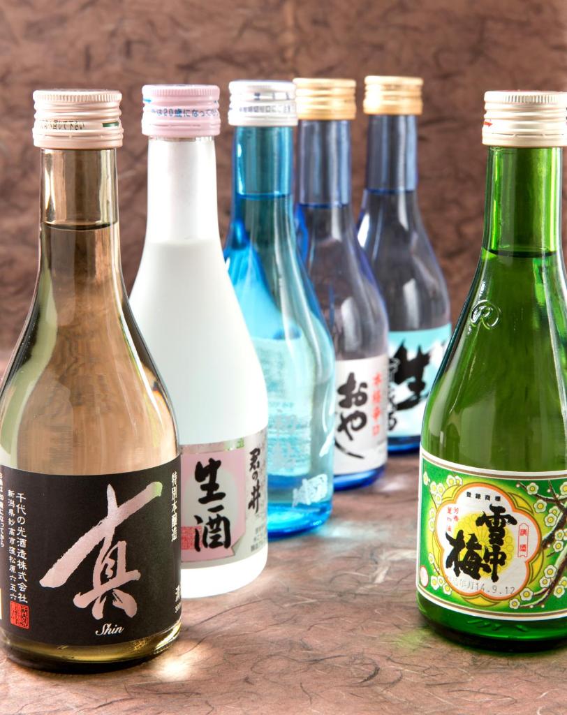 un groupe de bouteilles de vin sur une table dans l'établissement Akakura Hotel, à Myōkō