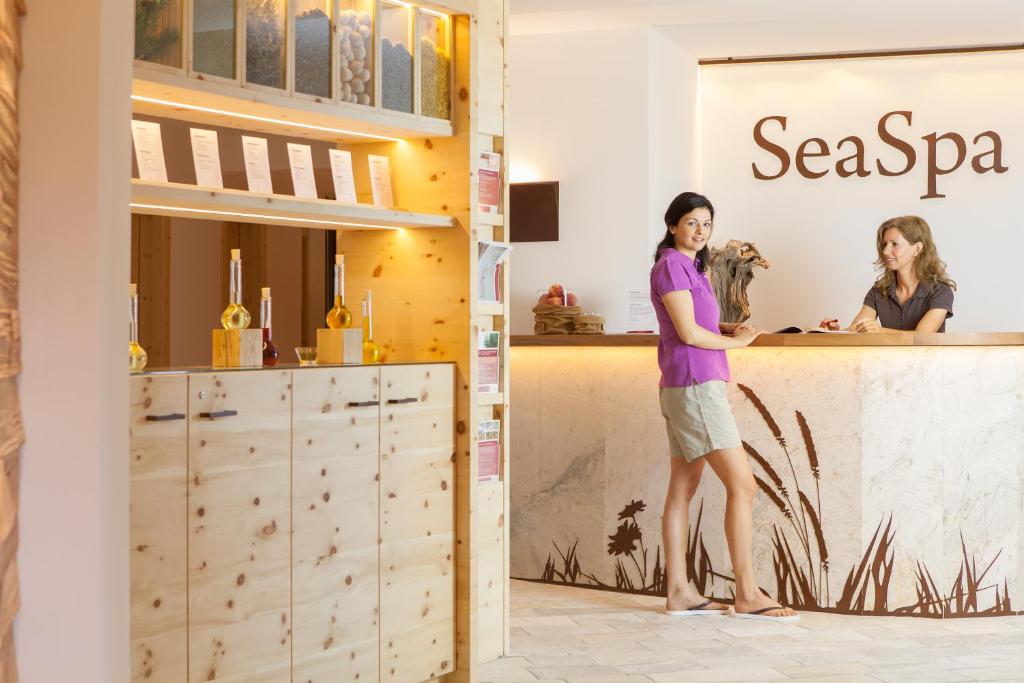 deux femmes debout à un comptoir dans un magasin dans l'établissement Hotel Weihrerhof, à Soprabolzano 49 autres photos