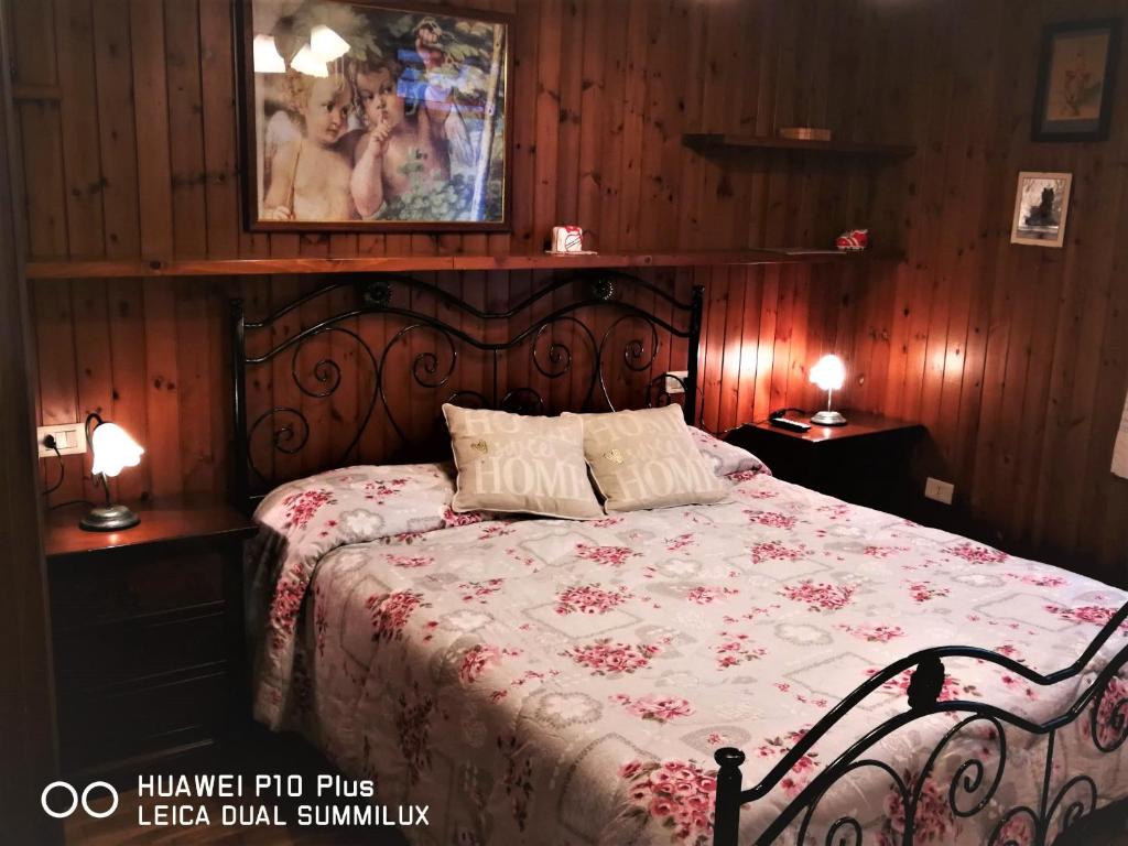 une chambre avec un lit avec un couvre-lit fleuri dans l'établissement Villa con piscina Assisi, à Assise