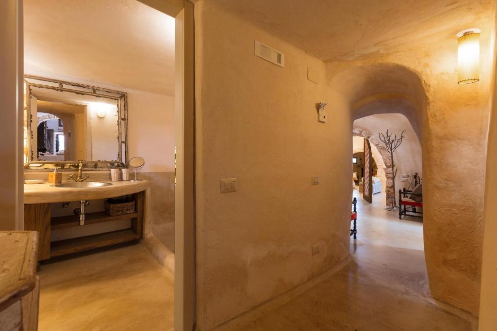 une salle de bain avec un lavabo et un miroir dans l'établissement Trulli di Monte Reale by Perle di Puglia, à Cisternino