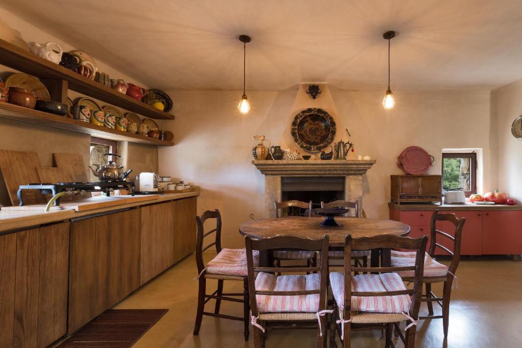 - une cuisine avec une table et une cheminée dans l'établissement Trulli di Monte Reale by Perle di Puglia, à Cisternino