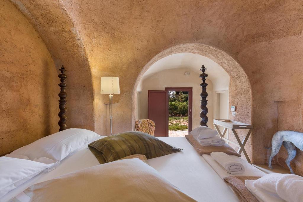 - une chambre avec un grand lit blanc et une voûte dans l'établissement Trulli di Monte Reale by Perle di Puglia, à Cisternino