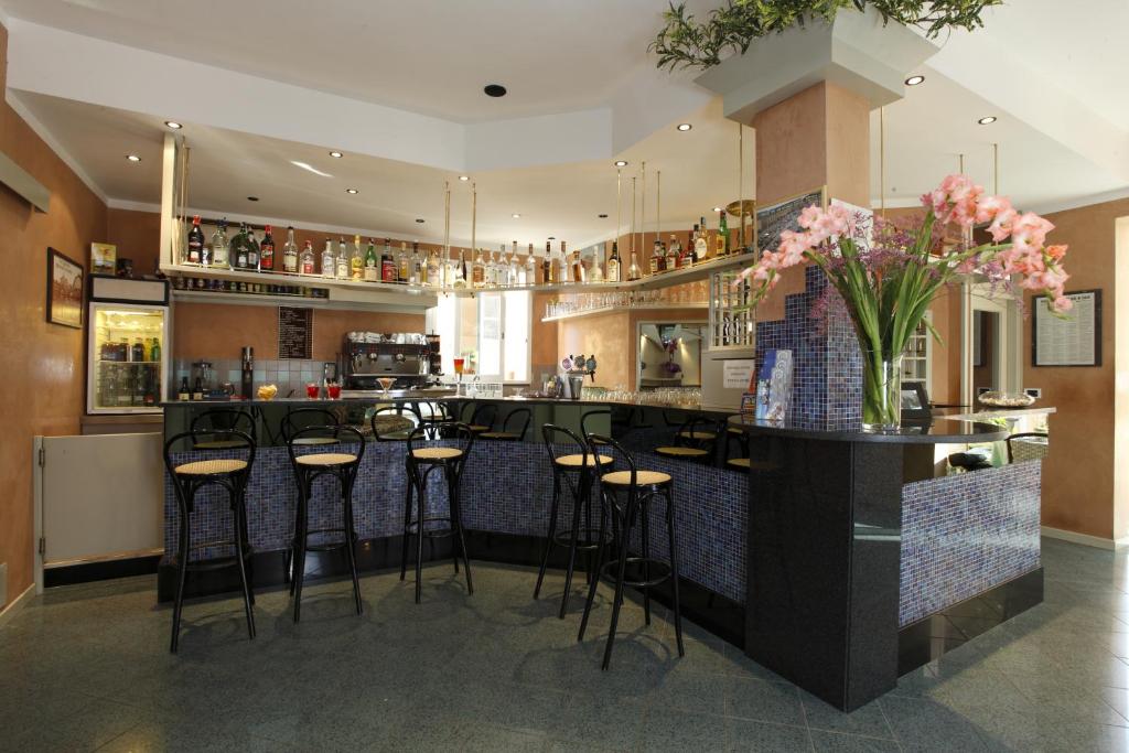 une cuisine avec un bar avec des tabourets et un comptoir dans l'établissement Hotel Conti, à Rimini
