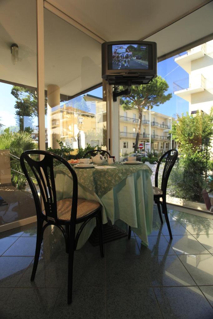 d'une table avec deux chaises et d'une télévision. dans l'établissement Hotel Conti, à Rimini