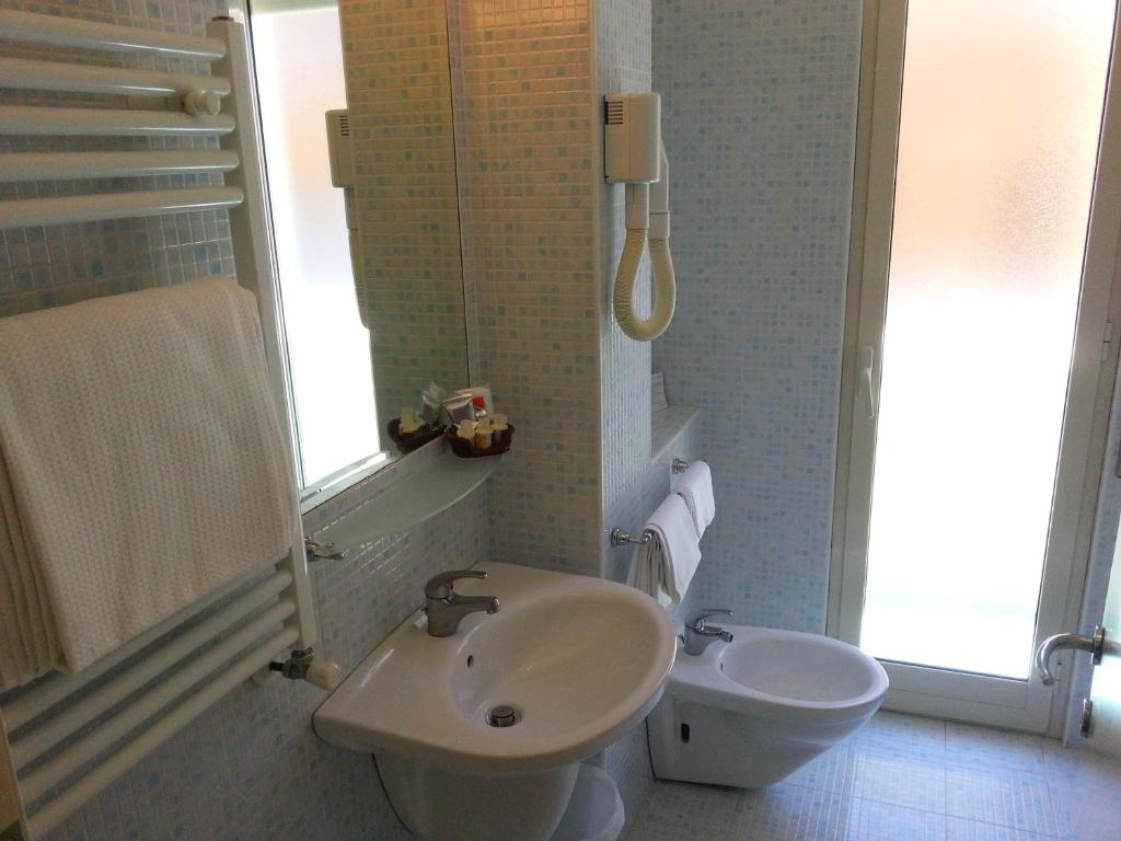 une salle de bain avec un lavabo et des toilettes dans l'établissement Hotel Mayor, à Sperlonga