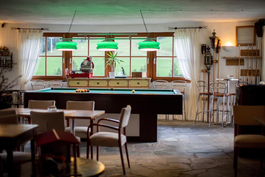 - un billard dans une salle avec des tables et des chaises dans l'établissement Al Plan, A mountain moving hotel, à San Vigilio Di Marebbe