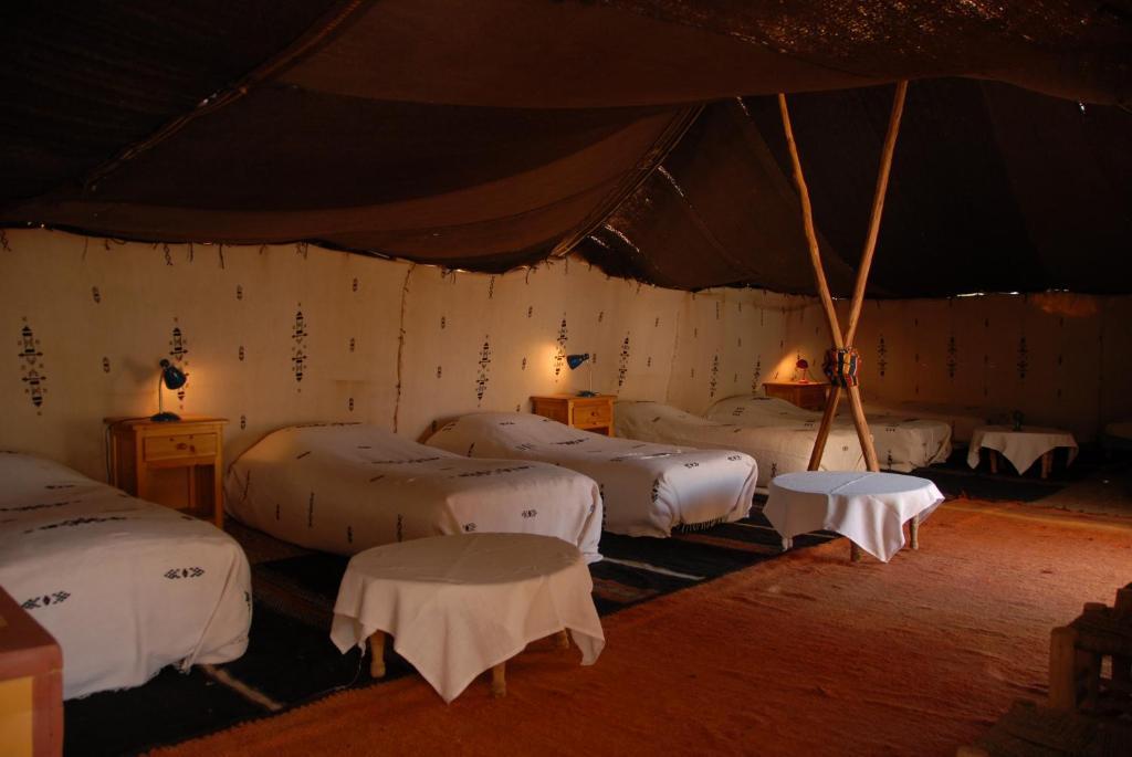 une chambre avec un groupe de lits dans une tente dans l'établissement Villa Zagora Ma Villa au Sahara, à Zagora