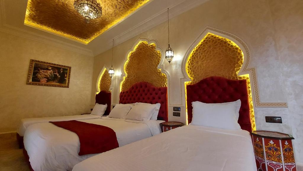 Cette chambre d'hôtel comprend 2 lits avec des têtes de lit rouges et dorées. dans l'établissement Riad Safir Marrakech, à Marrakech