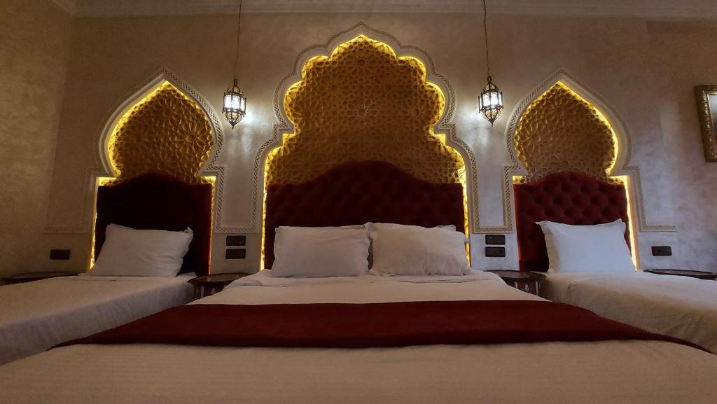 - une chambre avec 2 lits dotés de têtes de lit dorées dans l'établissement Riad Safir Marrakech, à Marrakech