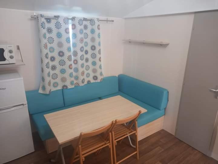 - un canapé bleu dans une petite chambre avec une table dans l'établissement Famille Peeters, à Camiers