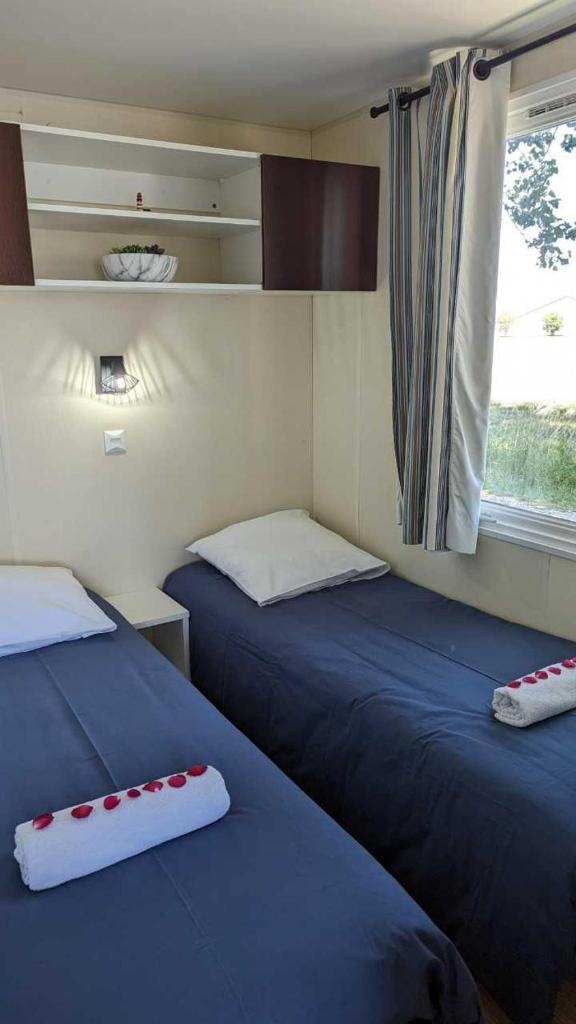 deux lits dans une petite pièce avec une fenêtre dans l'établissement Cottage flottant jacuzzi privé en option gamme supérieure, à Saint-Jean-de-Losne 9 autres photos