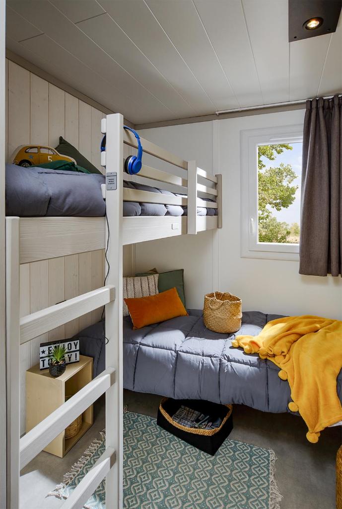 Cette chambre dispose de lits superposés et d'un canapé. dans l'établissement Camping Beau Rivage, à Navarrenx
