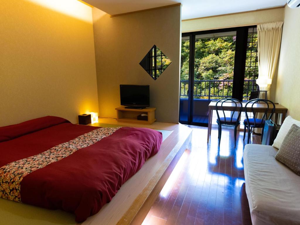 - une chambre avec un grand lit rouge et une télévision dans l'établissement Fulsato, à Tsuchihatakozan