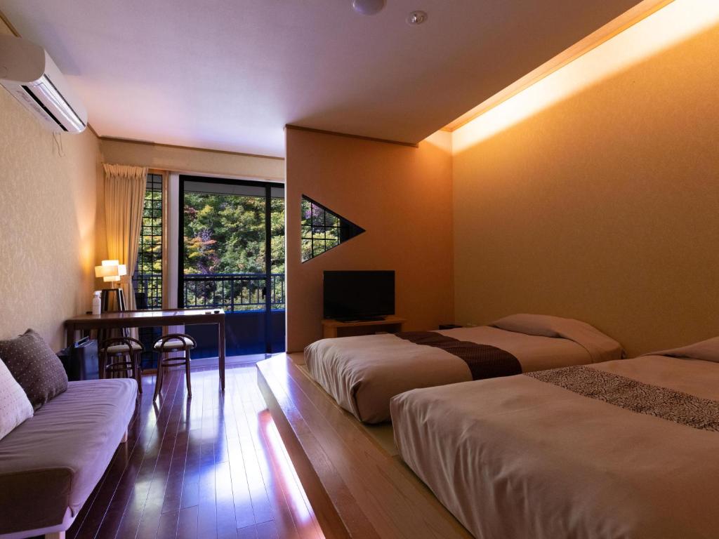 une chambre d'hôtel avec deux lits et une télévision dans l'établissement Fulsato, à Tsuchihatakozan