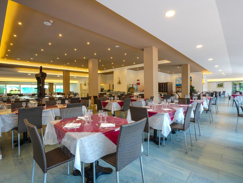 une salle à manger avec des tables et des chaises dans un restaurant dans l'établissement Cefalu Resort - Sporting Club, à Cefalù