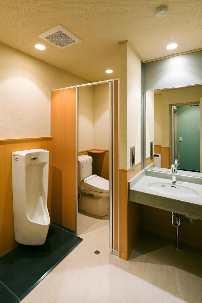La salle de bains est pourvue de toilettes, d'un lavabo et d'un urinoir. dans l'établissement Hotel Saginoyu, à Suwa
