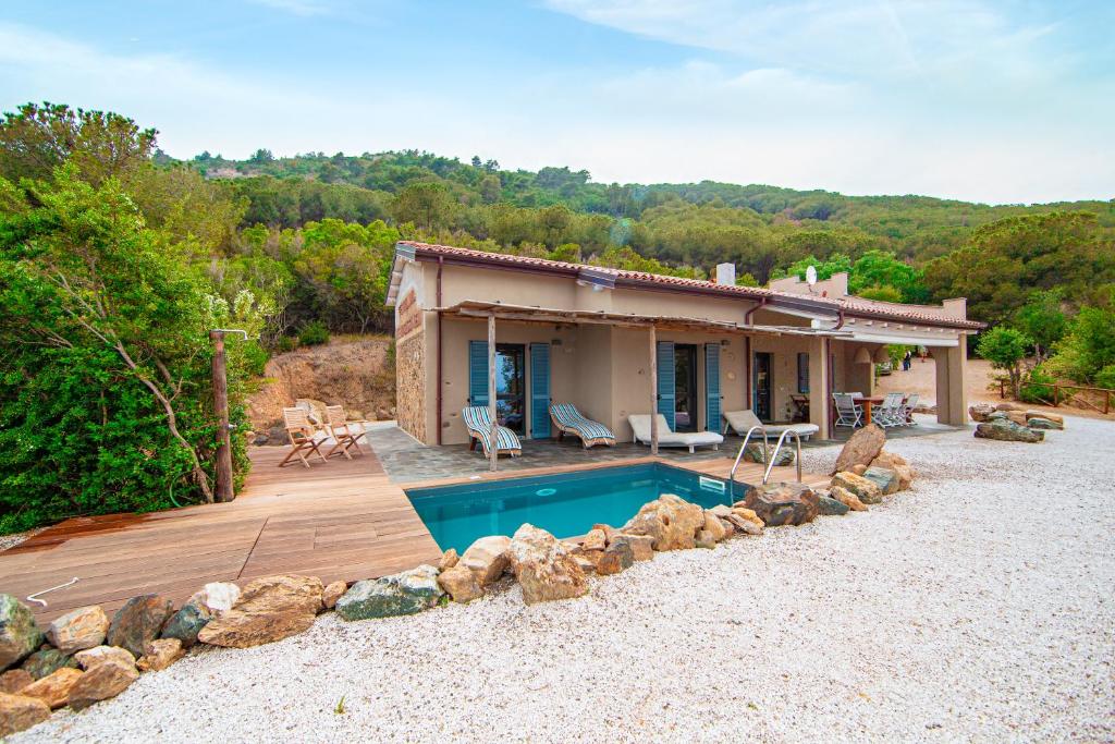 une maison avec une piscine devant dans l'établissement Tenuta Delle Ripalte, à Capoliveri