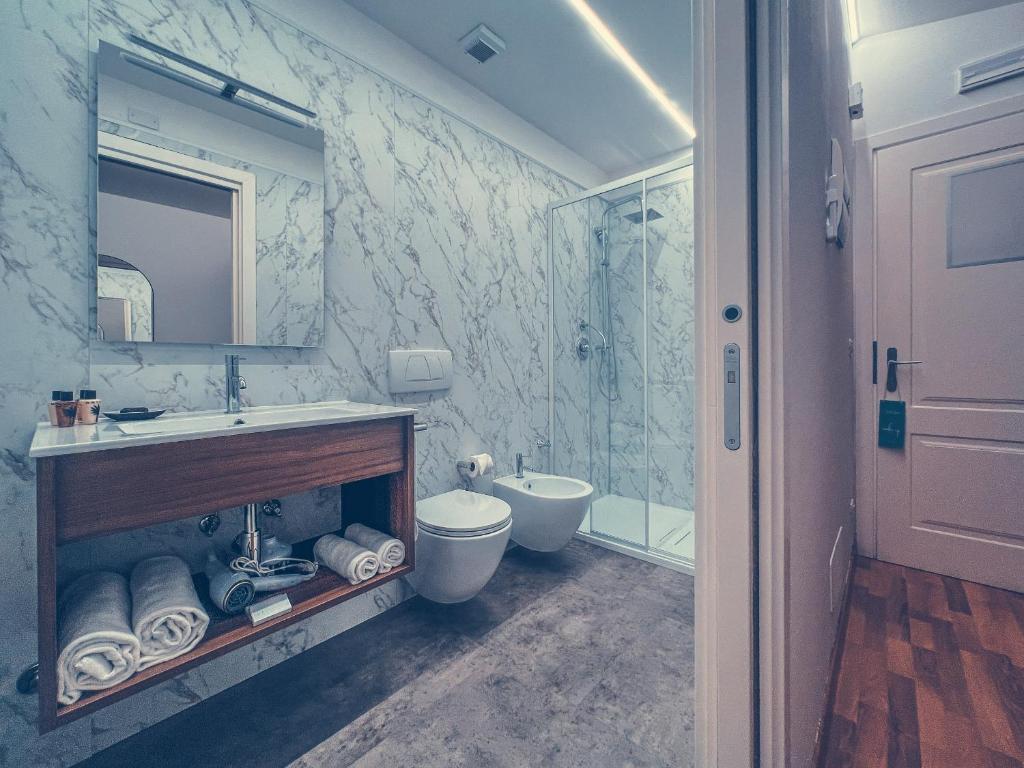 une salle de bain avec un lavabo, des toilettes et un miroir dans l'établissement Club del Sole Tenuta Primero Hotel, à Grado