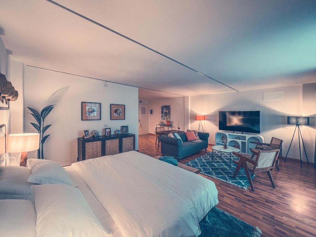une chambre avec un lit et un salon dans l'établissement Club del Sole Tenuta Primero Hotel, à Grado