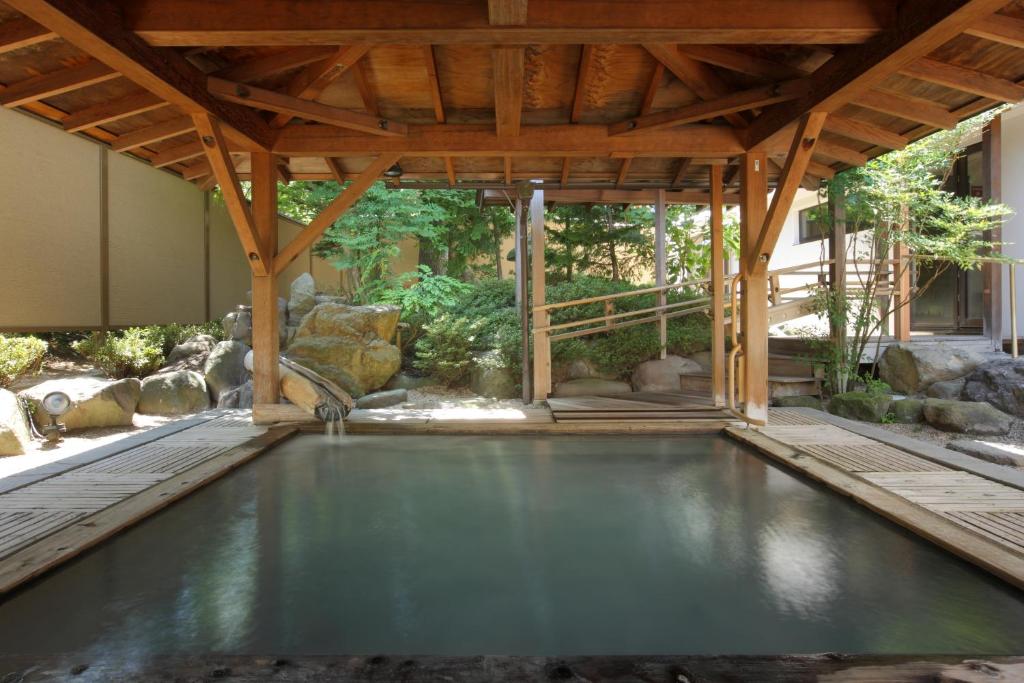- une piscine dans une maison dotée d'un toit en bois dans l'établissement Azumakan, à Nihommatsu