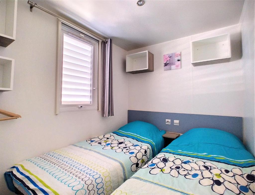 une chambre avec deux lits et une fenêtre dans l'établissement Mobil Home 6/8 Places vue dégagée, au Muy