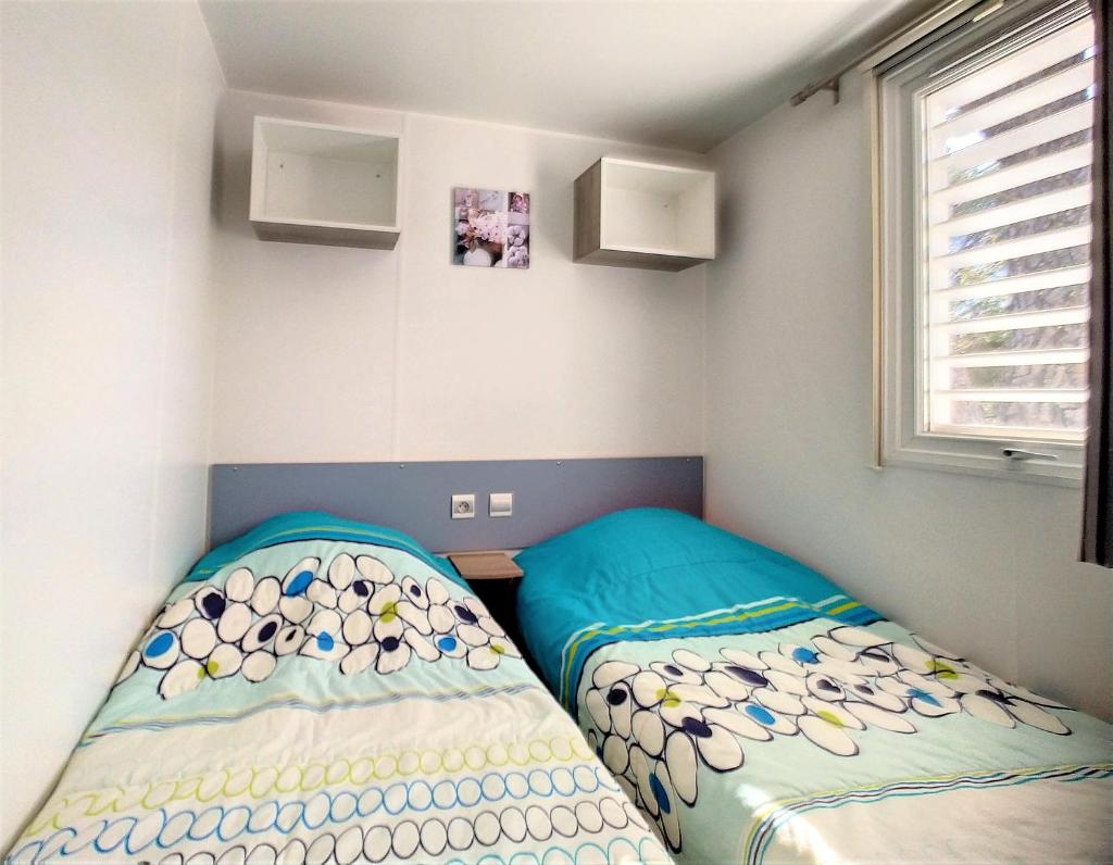 une chambre avec deux lits dans une pièce dans l'établissement Mobil Home 6/8 Places vue dégagée, au Muy