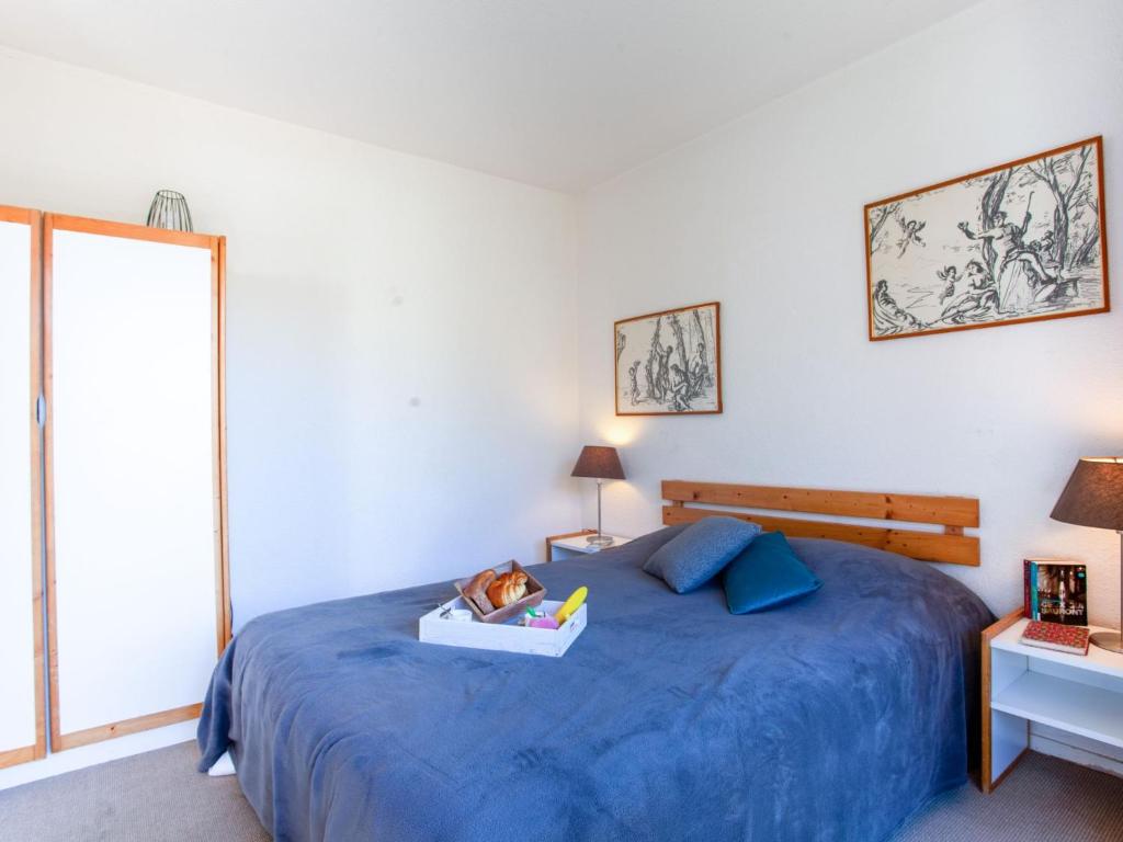 - une chambre avec un lit bleu et un livre dans l'établissement Apartment Lunik Orion-22 by Interhome, au Corbier