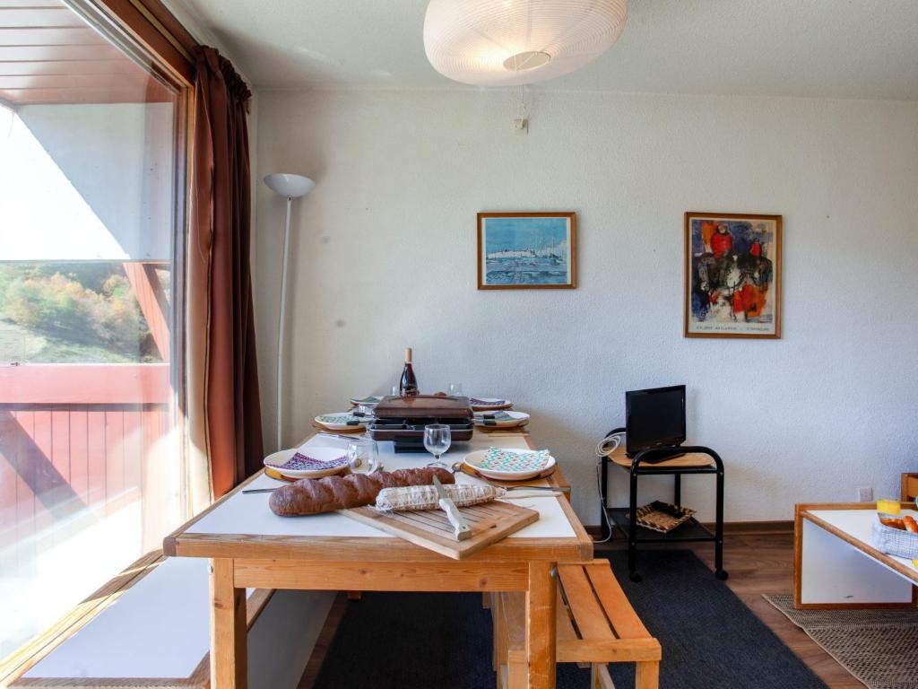 Cette chambre dispose d'une table en bois avec de la nourriture. dans l'établissement Apartment Lunik Orion-22 by Interhome, au Corbier 30 autres photos