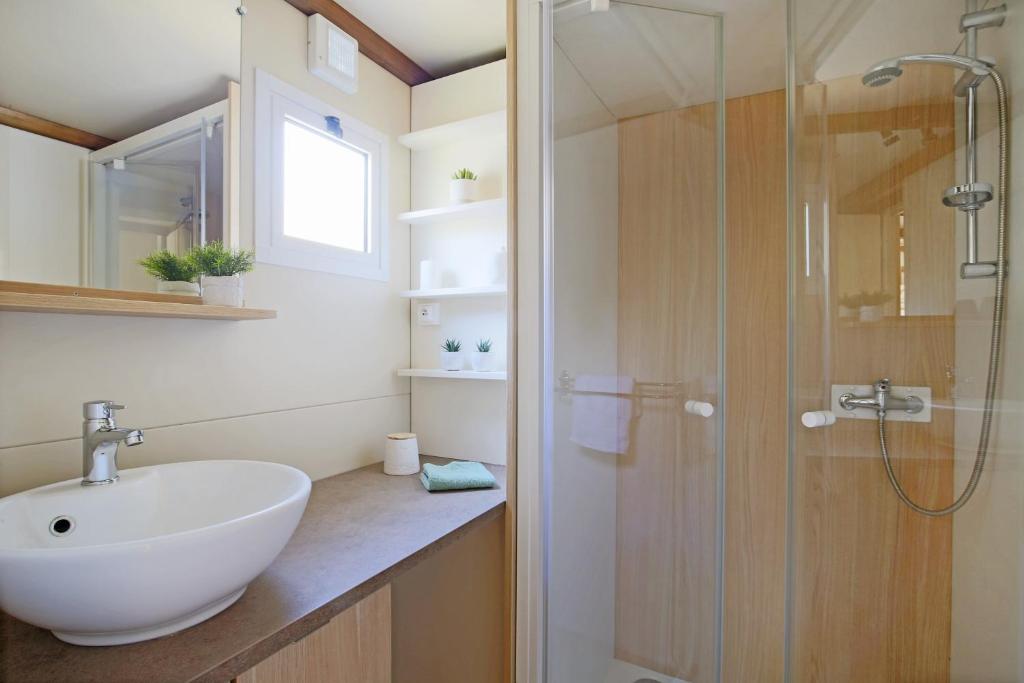 une salle de bain avec un lavabo et une douche dans l'établissement Camping Saint Laurent, à Ploemel