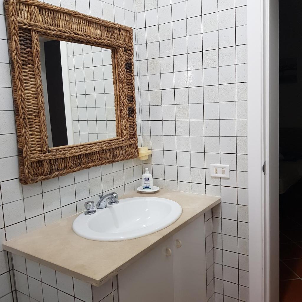 une salle de bain avec un lavabo et un miroir dans l'établissement Villa Brancasi con piscina, à Brindisi 48 autres photos