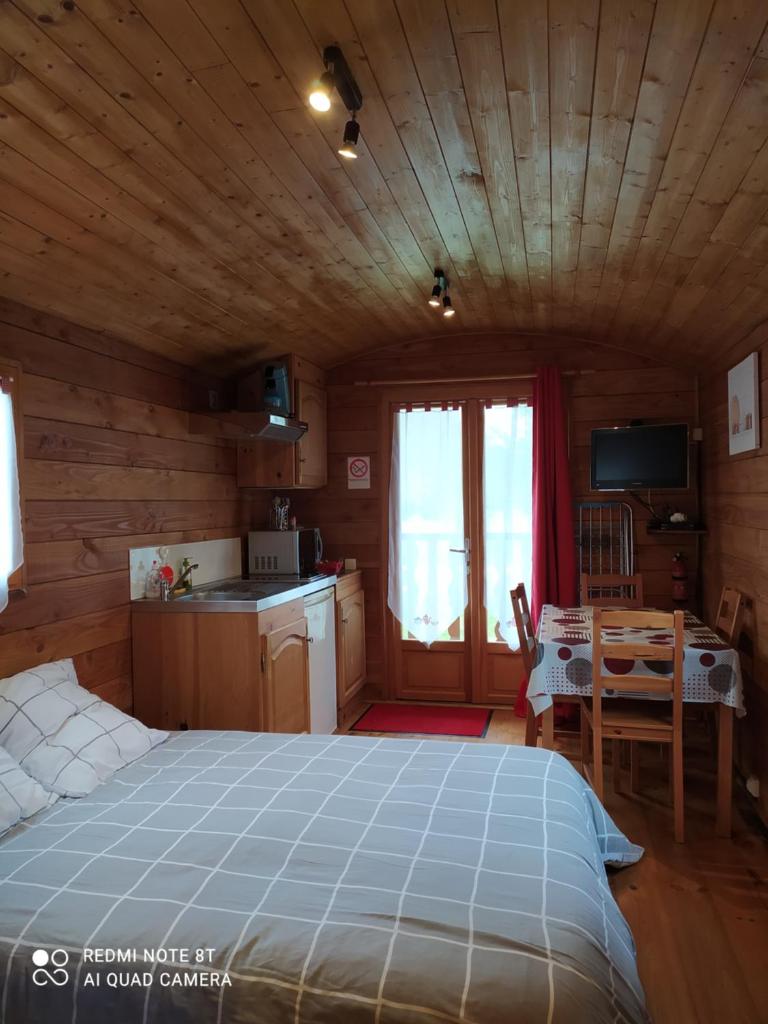 - une chambre avec un grand lit dans une cabane en rondins dans l'établissement Domaine Moulin d'Elemiah, à Gémozac
