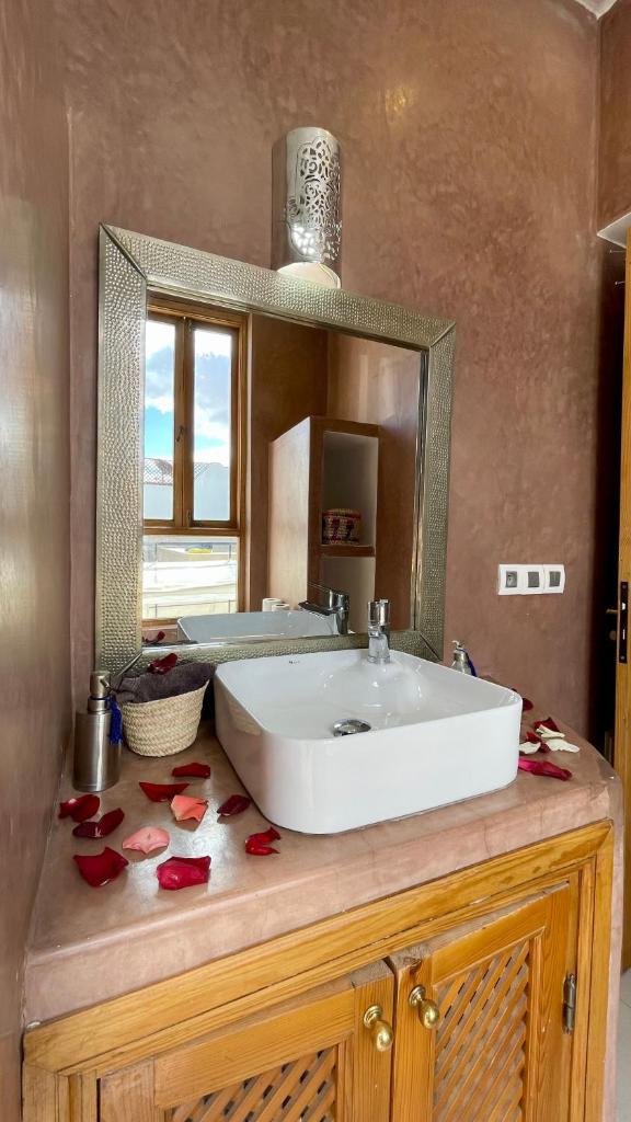 une salle de bain avec un lavabo blanc et un miroir dans l'établissement Riad Al Hamama, à Marrakech