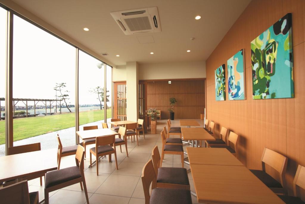 une salle à manger avec tables, chaises et fenêtres dans l'établissement Bayside Square Kaike Hotel, à Yonago