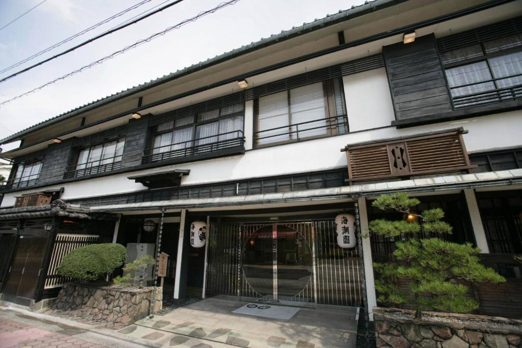 un bâtiment avec des fenêtres noires et une porte dans l'établissement Kaichoen, à Yonago
