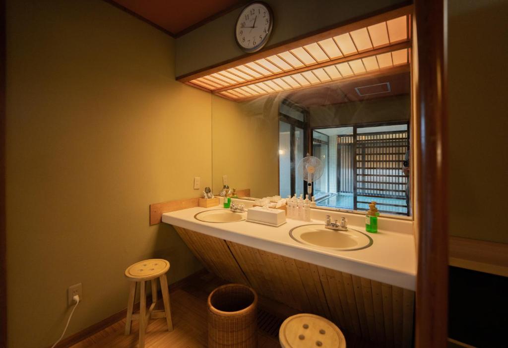 une salle de bain avec deux lavabos et un grand miroir dans l'établissement Sakahijiri Nikko, à Nikkō