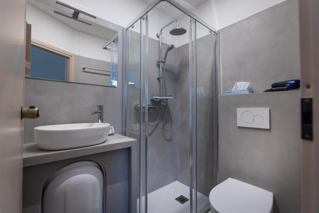 une salle de bain avec douche, lavabo et toilettes dans l'établissement Hotel Al Molino, à Malcesine