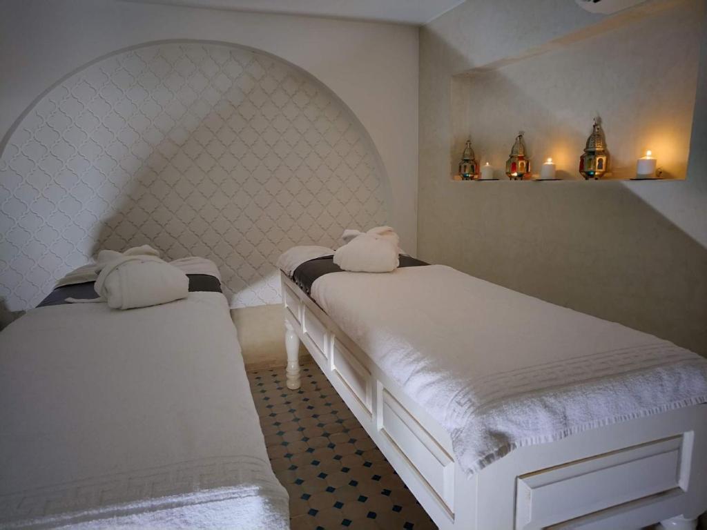 - 2 lits blancs dans une chambre avec une tête de lit dans l'établissement Riad El Arco ROOFTOP POOL & Spa, à Marrakech
