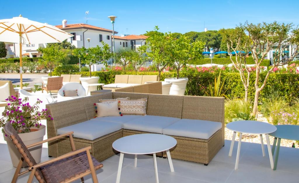 un patio avec un canapé, des tables et des chaises dans l'établissement International Hotel, à Cavallino-Treporti