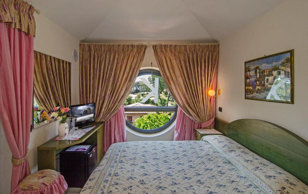 une chambre avec un lit et une grande fenêtre dans l'établissement Hotel Kyrton, à Forte dei Marmi 149 autres photos